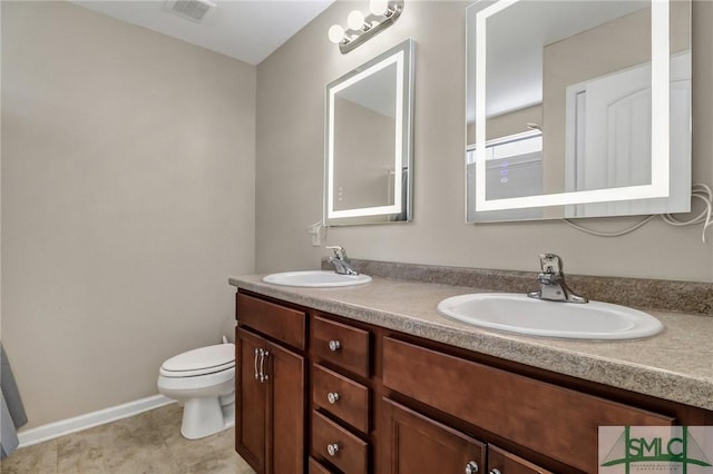 bathroom featuring a sink, visible vents, toilet, and double vanity