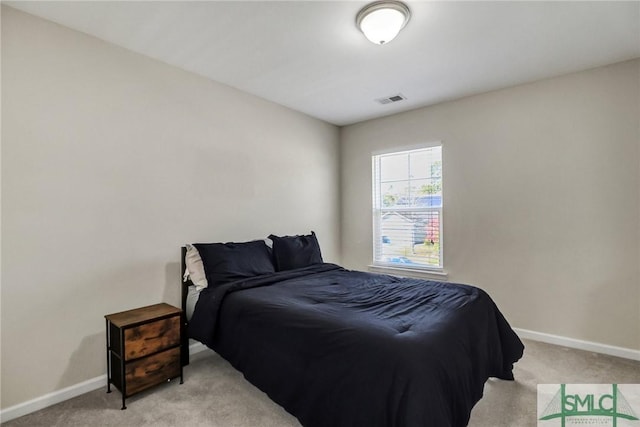 bedroom featuring visible vents, light carpet, and baseboards