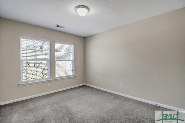 carpeted spare room featuring visible vents and baseboards