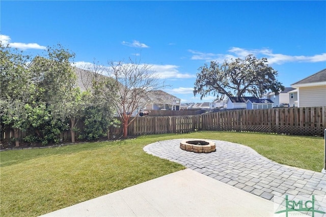 view of yard with a fenced backyard, a fire pit, and a patio