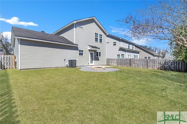 rear view of property featuring a yard, fence, central AC, and an outdoor fire pit