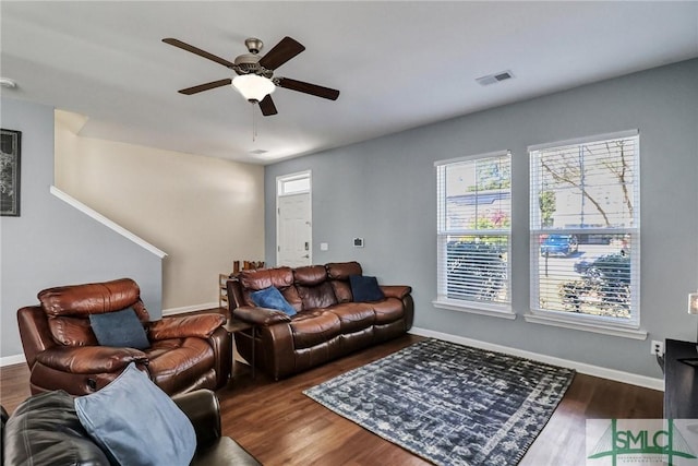 living room with ceiling fan, visible vents, baseboards, and wood finished floors