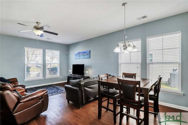 dining room featuring visible vents, baseboards, dark wood-type flooring, and ceiling fan with notable chandelier