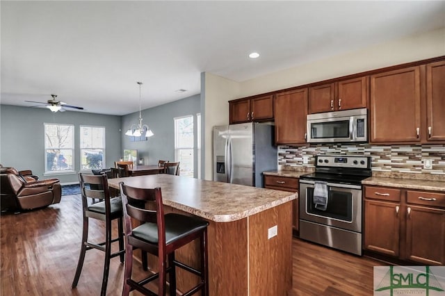 kitchen featuring decorative backsplash, a kitchen island, appliances with stainless steel finishes, and open floor plan