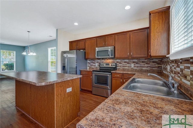 kitchen with a sink, decorative backsplash, dark wood-style floors, and stainless steel appliances