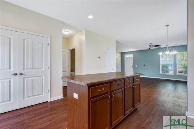 kitchen with dark countertops, baseboards, dark wood-style floors, and a center island