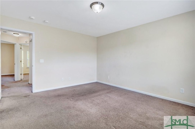 unfurnished room with baseboards and carpet flooring