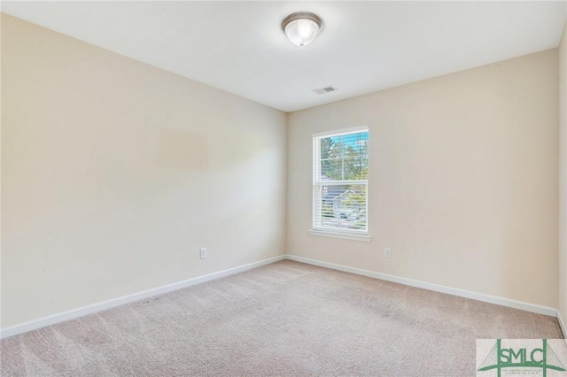 spare room with baseboards, visible vents, and light colored carpet