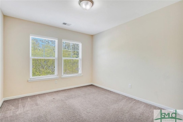 spare room featuring baseboards, carpet flooring, and visible vents
