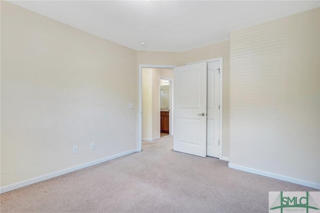 unfurnished bedroom with baseboards, a closet, and light carpet