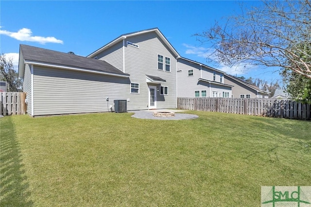 back of property with central AC unit, a fire pit, a fenced backyard, and a yard