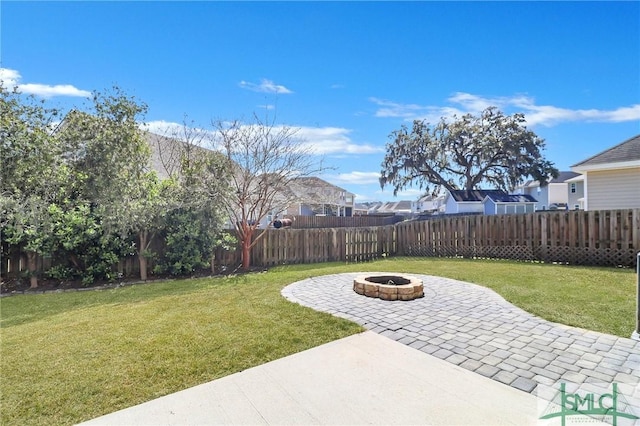 view of yard with a patio, a fenced backyard, and a fire pit