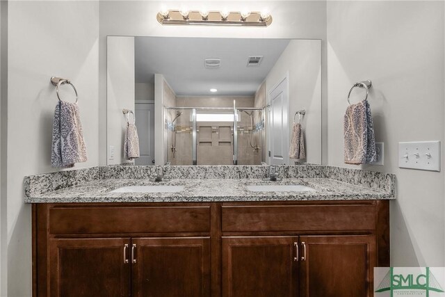 full bathroom featuring double vanity, visible vents, a shower stall, and a sink