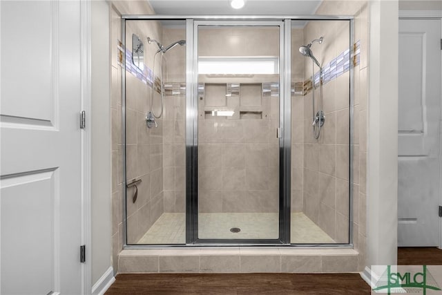 bathroom with wood finished floors and a stall shower