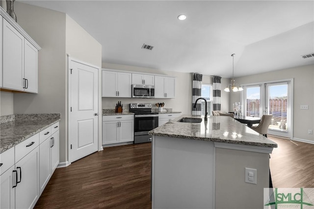 kitchen with visible vents, dark wood finished floors, a sink, stainless steel appliances, and white cabinetry