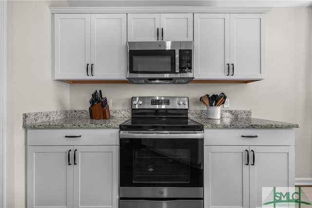 kitchen with light stone countertops, appliances with stainless steel finishes, and white cabinets