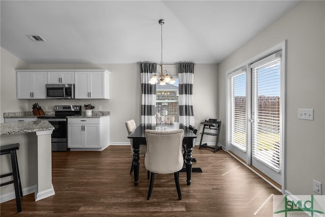 dining area with visible vents, dark wood-style floors, baseboards, a chandelier, and vaulted ceiling