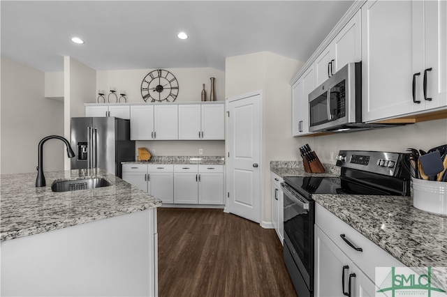 kitchen featuring light stone counters, a sink, dark wood-type flooring, white cabinets, and appliances with stainless steel finishes