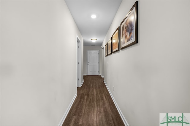 hall with dark wood-type flooring and baseboards