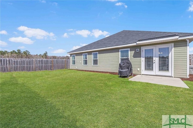 back of property featuring a yard, french doors, fence, and roof with shingles