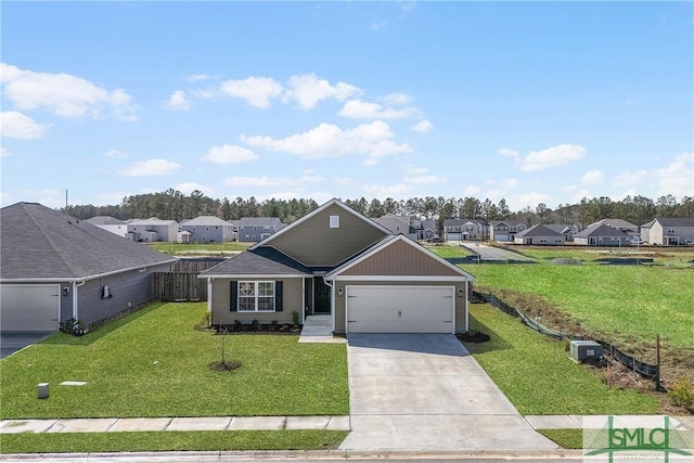 view of front of house featuring a front yard, fence, a residential view, and driveway