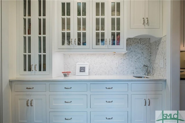 bar with a sink, indoor wet bar, and tasteful backsplash