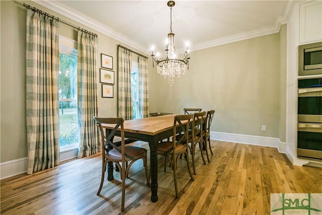 dining area featuring crown molding, light wood-style flooring, and baseboards