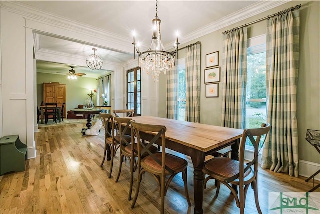 dining room with ceiling fan with notable chandelier, light wood-type flooring, and crown molding