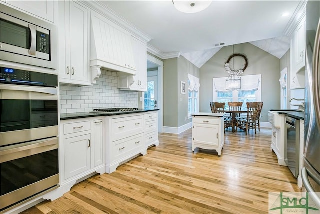 kitchen with white cabinetry, dark countertops, backsplash, and appliances with stainless steel finishes