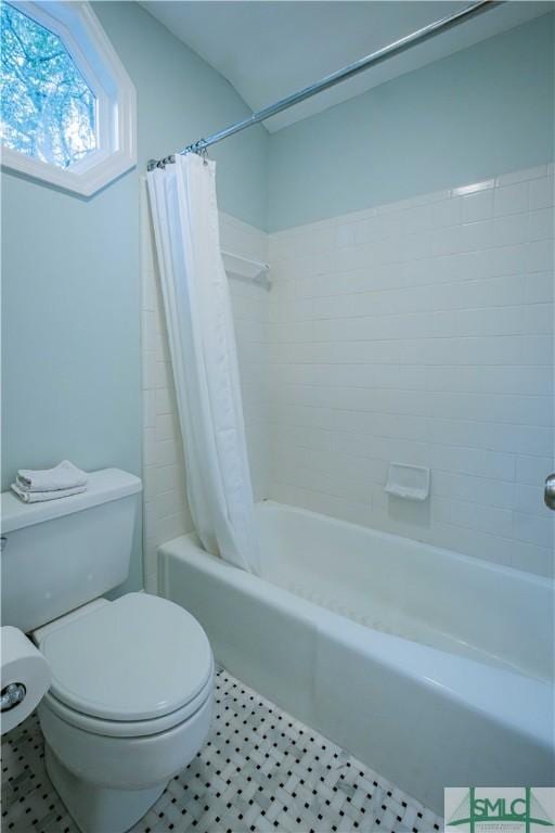 bathroom with tile patterned flooring, toilet, and shower / bath combo with shower curtain