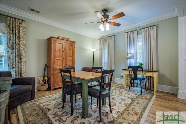 dining area with visible vents, crown molding, light wood-type flooring, and baseboards