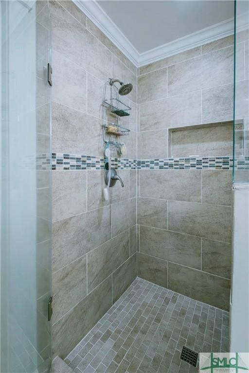 full bathroom with a tile shower and ornamental molding