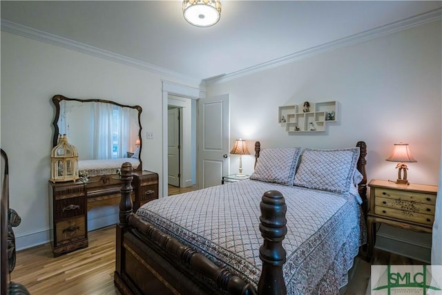 bedroom featuring crown molding, baseboards, and wood finished floors