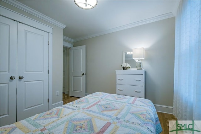 bedroom featuring crown molding, wood finished floors, a closet, and baseboards