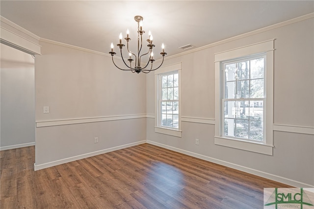 unfurnished room with wood finished floors, baseboards, visible vents, an inviting chandelier, and ornamental molding