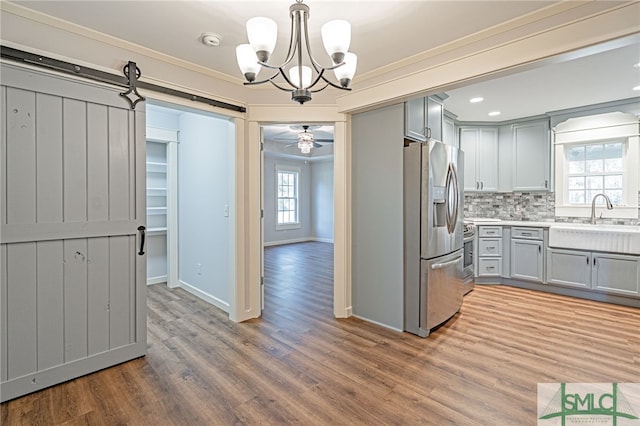 kitchen featuring light wood finished floors, a sink, gray cabinets, and stainless steel fridge with ice dispenser