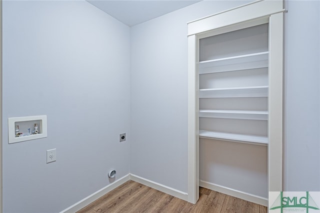 clothes washing area featuring baseboards, washer hookup, laundry area, wood finished floors, and electric dryer hookup