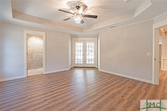 empty room with visible vents, french doors, a raised ceiling, and wood finished floors