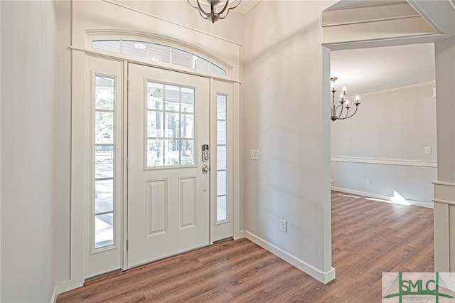 foyer with an inviting chandelier, wood finished floors, baseboards, and a wealth of natural light