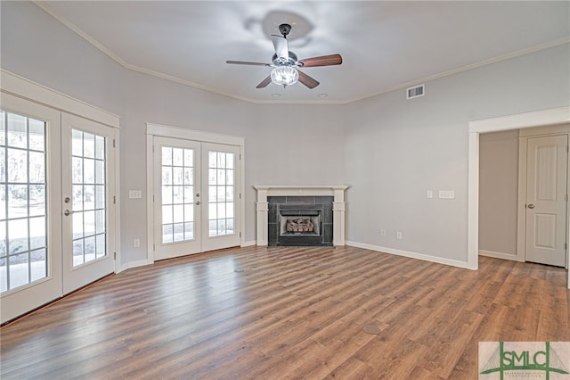 unfurnished living room with french doors, plenty of natural light, visible vents, and a tile fireplace