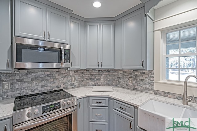 kitchen featuring a sink, appliances with stainless steel finishes, and gray cabinets