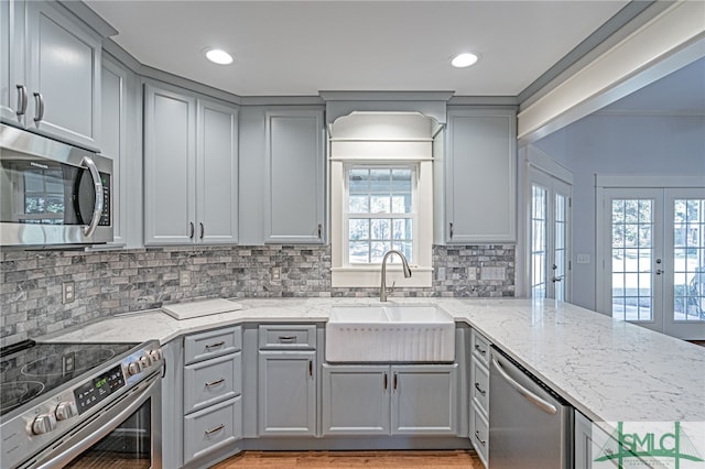 kitchen featuring gray cabinetry, stainless steel appliances, french doors, and a sink