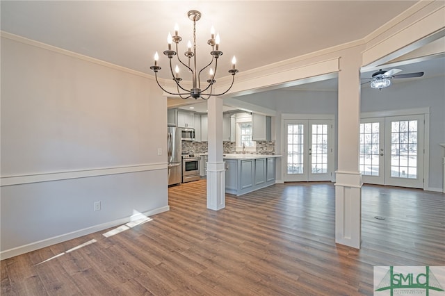 unfurnished dining area featuring french doors, baseboards, dark wood-style floors, and ornamental molding