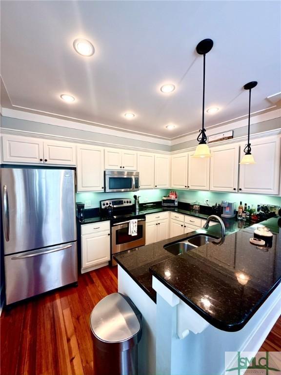 kitchen with a sink, dark wood-style floors, white cabinetry, and stainless steel appliances