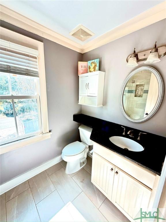 bathroom featuring baseboards, visible vents, toilet, and vanity