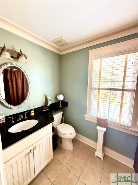 bathroom with vanity, baseboards, tile patterned flooring, crown molding, and toilet