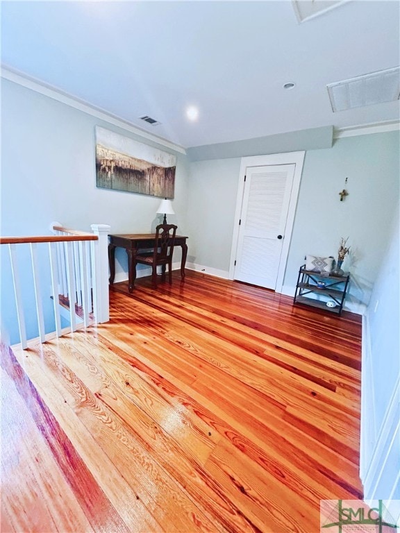 interior space with wood finished floors, attic access, baseboards, and visible vents