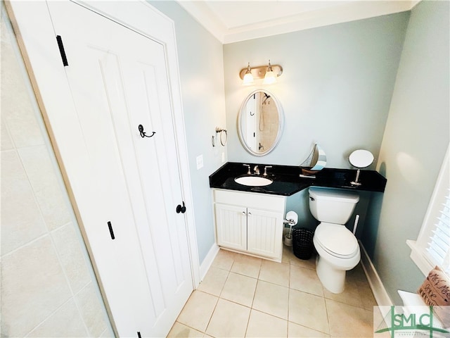 bathroom with crown molding, baseboards, toilet, vanity, and tile patterned flooring