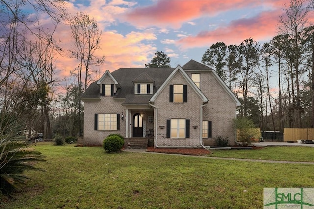 view of front facade featuring a lawn and brick siding