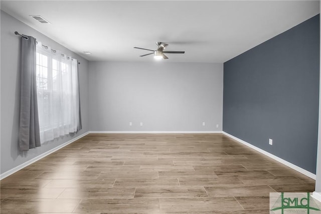 unfurnished room featuring ceiling fan, light wood-style floors, visible vents, and baseboards